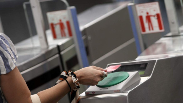 Una mujer pasa su billete en el torno del Metro madrileño