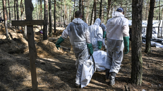 Forenses ucranianos recuperan un cadáver de la fosa común en un bosque en las afueras de Izyum