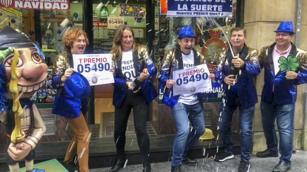 Responsables de la administración de lotería de la calle Jovellanos, número 8, de Oviedo, celebran la venta de un décimo del Gordo de Navidad