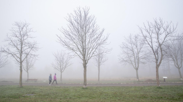 Dos mujeres pasean bajo la niebla en Vitoria, en el que el frío se ha dejado notar de nuevo con intensidad