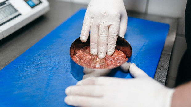 Un cocinero prepara un filete de hamburguesa