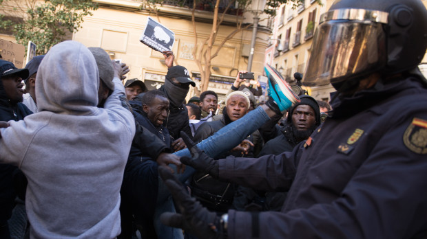 Un manifestante de origen subsahariano trata de patear a un agente de la Policía Nacional, en 2018, en Lavapiés (Madrid)