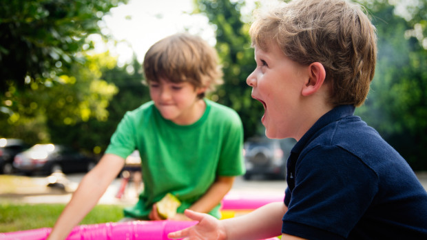 Dos niños juegan en el parque con agua