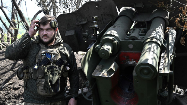 A Ukrainian artilleryman stands next to a 152 mm towed gun-howitzer D-20 on the front line near Bakhmut, eastern Ukraine, on July 20, 2023, amid the Russian invasion of Ukraine. (Photo by Genya SAVILOV / AFP)