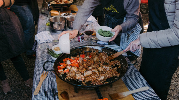Un grupo de extranjeros prepara una paella