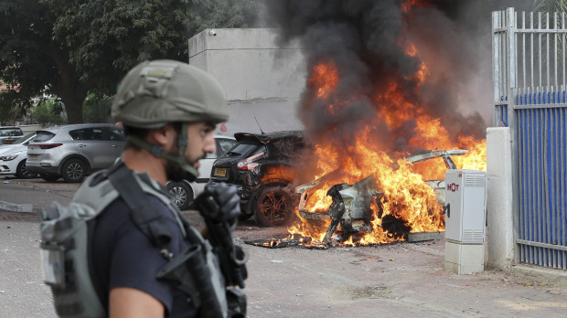 Un miembro soldado israelí, cerca de un coche alcanzado por un cohete disparado desde Gaza