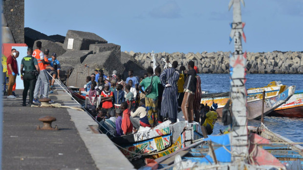 Trabajadores de la Cruz Roja y agentes de la Guardia Civil, junto a uno de los cayucos llegados a El Hierro (Santa Cruz de Tenerife)