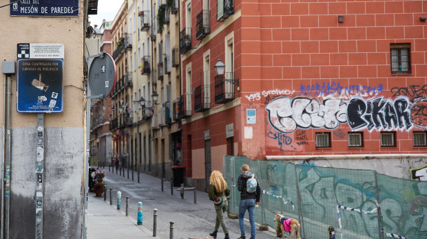 Una pareja pasea a un perro por el madrileño barrio de Lavapiés