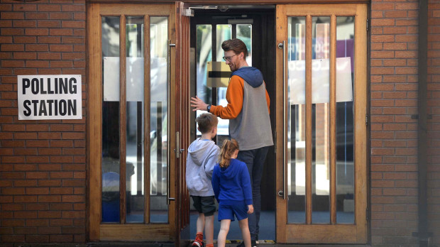Una hombre, junto a sus hijos, entrando a un colegio electoral en County Down, Irlanda del Norte