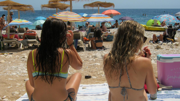 Dos chicas fuman en una playa de Benidorm, esta semana