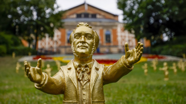 Una de las esculturas doradas de Wagner, obra del artista Ottmar Hoerl stand on the lawn in front of the 19th century Bayreuth Festival Opera House before the opening of the 112th Bayreuth Opera Festival (Festspiele), in Bayreuth, Germany, 25 July 2023. The Richard Wagner festival opens with the opera Parsifal and runs until 28 August. (Alemania) EFE/EPA/RONALD WITTEK