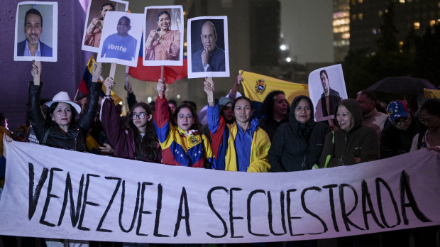 Venezolanos residentes en México sostienen una pancarta que dice "Venezuela secuestrada" durante una protesta contra el presidente venezolano Nicolás Maduro