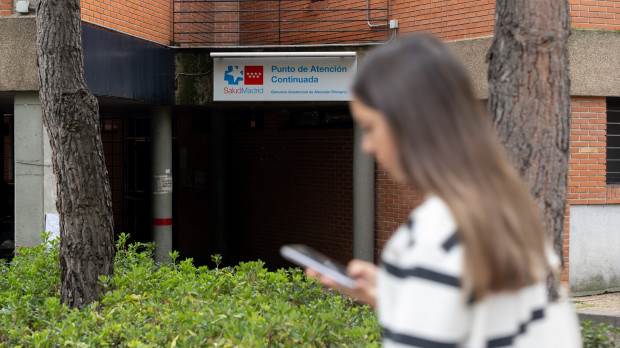 Una joven camina frente a un centro de atención continuada en Alcorcón