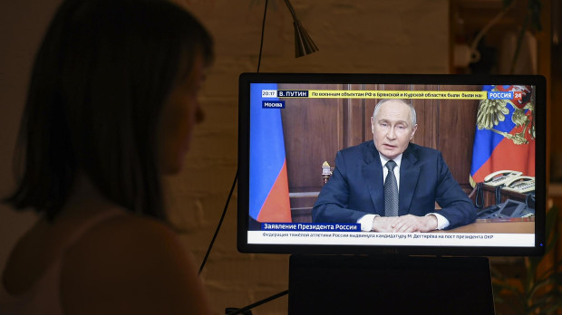 Una persona observa el discurso televisado del presidente ruso, Vladimir Putin, en Moscú