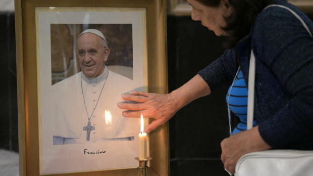 Una señora reza por el Papa Francisco