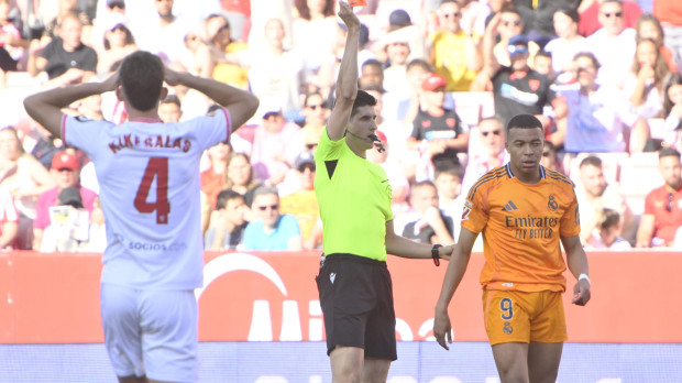 El colegiado muestra una cartulina en el partido de la jornada 37 entre Sevilla y Real Madrid