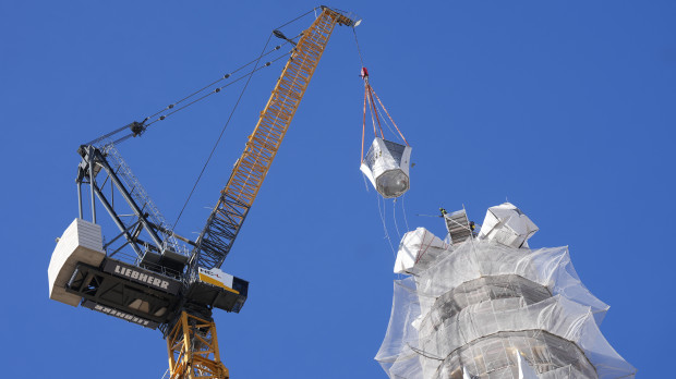 Una grúa coloca la última pieza de la torre de Jesucristo de la Sagrada Familia