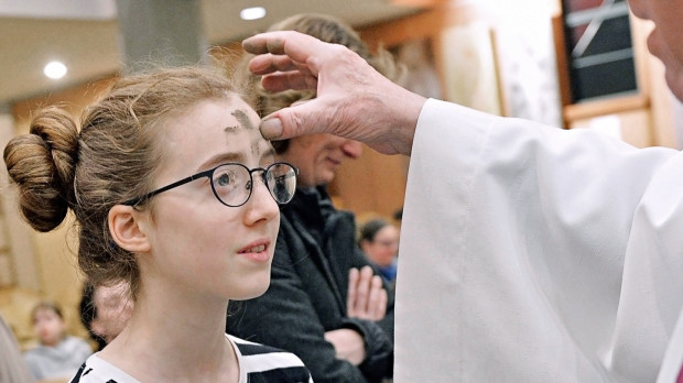 Un sacerdote impone la ceniza a una niña durante un servicio el Miércoles de Ceniza, en la iglesia de Notre-Dame d'Esperance en París.