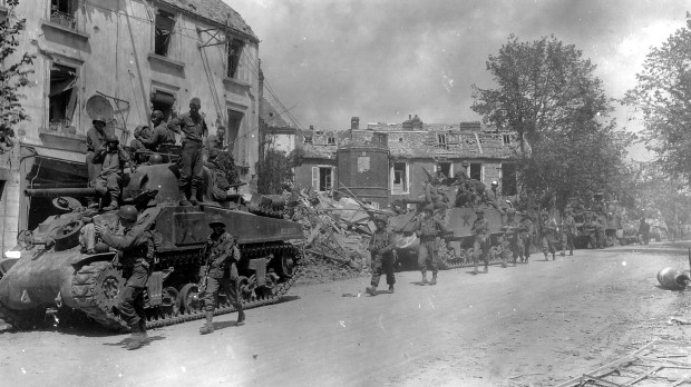 Fuerzas blindadas y de infantería estadounidenses atraviesan la devastada ciudad de Coutances, Francia, en la nueva ofensiva contra los nazis
