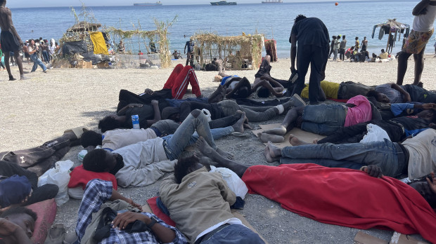 CEUTA, 09/08/2026.- Numerosos inmigrantes permanecen en la playa del Trampolín que se ha transformado en un asentamiento desde la entrada masiva registrada a finales de julio en la ciudad Ceuta.  EFE/Reduan