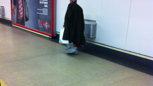 Pobre calzado con bolsas en los pies en el Metro