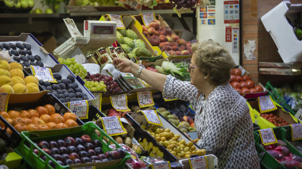 Una mujer compra en uno de los puestos del mercado de abastos de Triana (archivo)