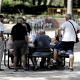 Varios pensionistas juegan al dominó en un parque de Madrid.