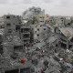 Rescatistas palestinos inspeccionan el lugar del bombardeo israelí contra un edificio residencial en el barrio de Shujaiyya, en la Ciudad de Gaza