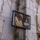 Un hombre enciende una vela junto a una foto del Papa Francisco en la Ciudad Vieja de Jerusalén