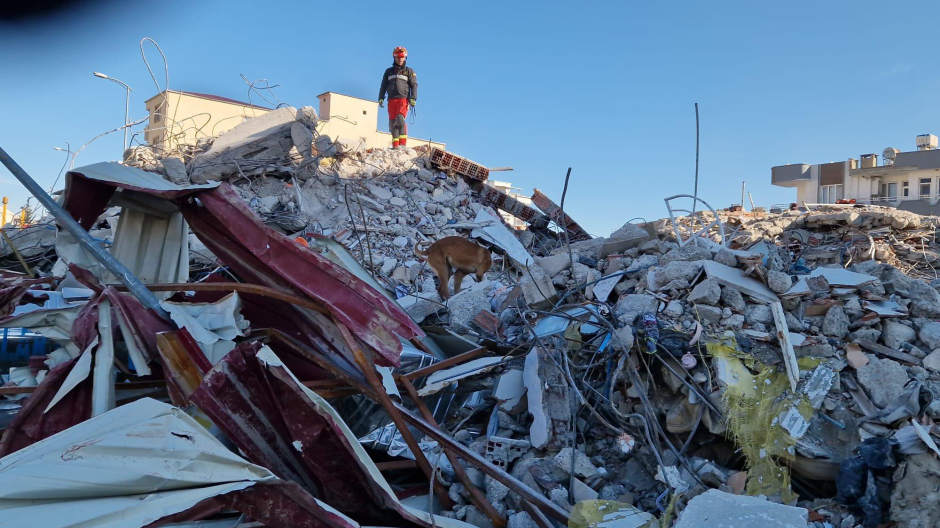 Un miembro de la UME escala sobre los escombros de un edificio en Islahiye (Turquía)