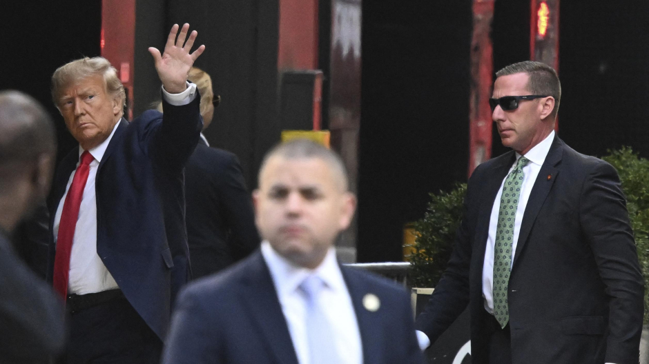 Former US President Donald Trump (L) waves as he arrives at Trump Tower in New York on April 3, 2023. - Trump arrived on April 3, 2023 in New York where he will surrender to unprecedented criminal charges, taking America into uncharted and potentially volatile territory as he seeks to regain the presidency. The 76-year-old Republican, the first US president ever to be criminally indicted, will be formally charged Tuesday over hush money paid to a porn star during the 2016 election campaign. (Photo by Ed JONES / AFP) / ALTERNATE CROP
