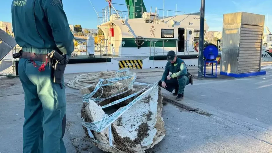 Agentes de la Guardia Civil con los restos óseos de la ballena en el Puerto de Villajoyosa