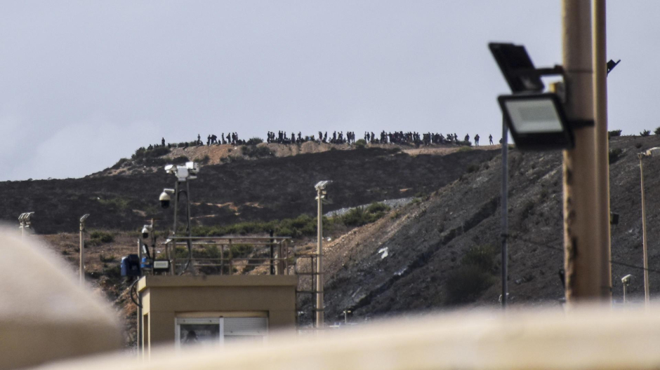 ecenas de personas se congregan en un monte cercano a la frontera con Ceuta para intentar cruzar a la ciudad española