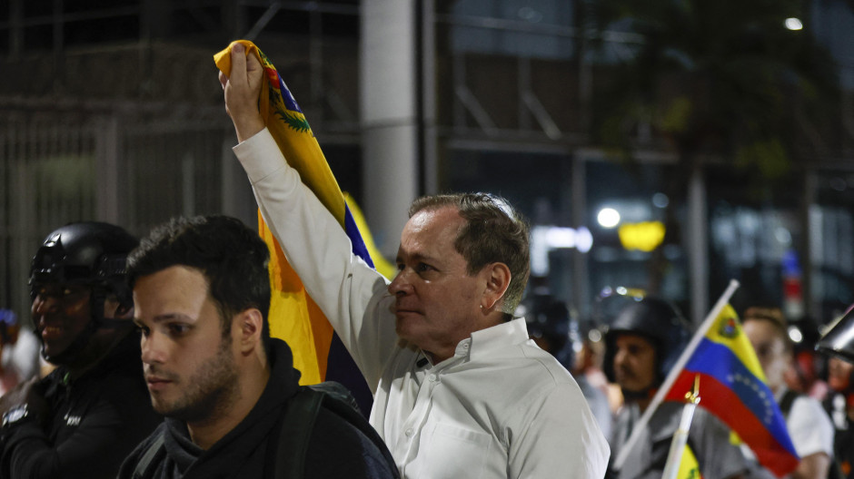 El opositor Juan Pablo Guanipa sostiene la bandera de Venezuela durante las horas que ha sido excarcelado