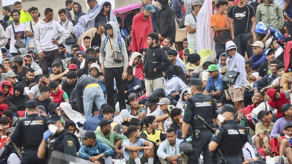 Un grupo de policías custodiando a un grupo de inmigrantes ilegales en Ceuta