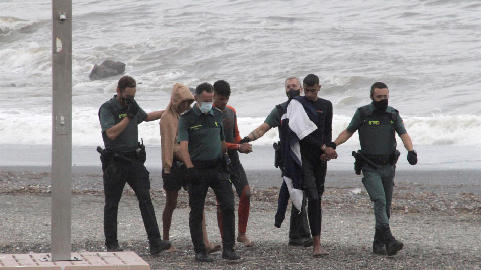 Miembros de la Guardia Civil detienen a varios de los inmigrantes que han intentado llegar a nado hoy Miércoles a la playa del Tarajal, en Ceuta. EFE / Reduan.