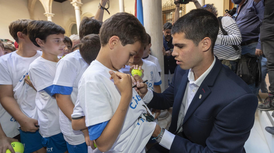 El tenista Carlos Alcaraz firmando un autógrafo a un joven aficionado