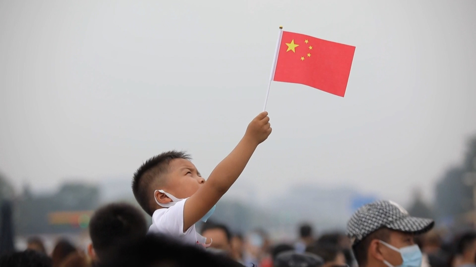 Joven chino levantando la bandera de su país