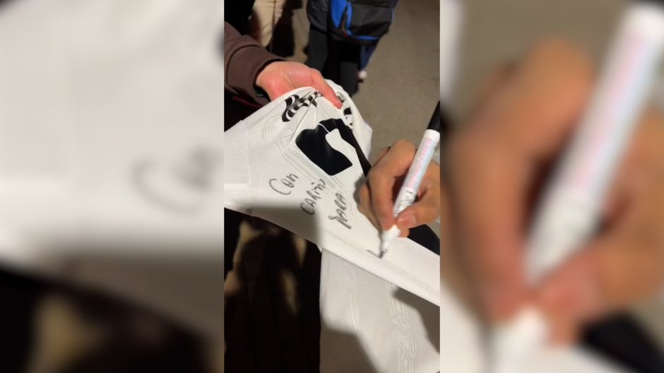 Rodrygo firma la camiseta que le regalará a un aficionado