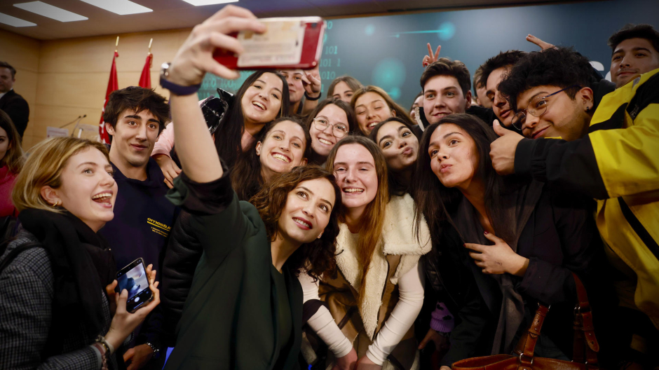 La presidenta de la Comunidad de Madrid, Isabel Díaz Ayuso (c-i) se hace un selfie con un grupo de estudiantes