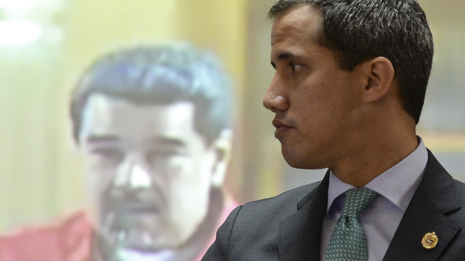 Juan Guaidó frente a una pantalla que representa al dictador Nicolás Maduro durante una sesión en la Asamblea Nacional en Caracas