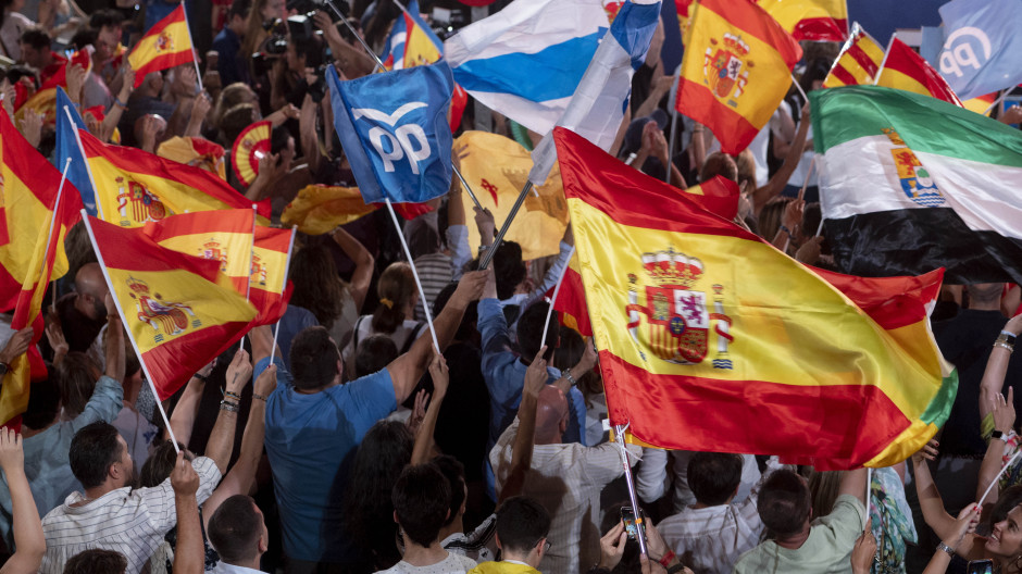 Banderas de España y del Partido Popular en las puertas de Génova