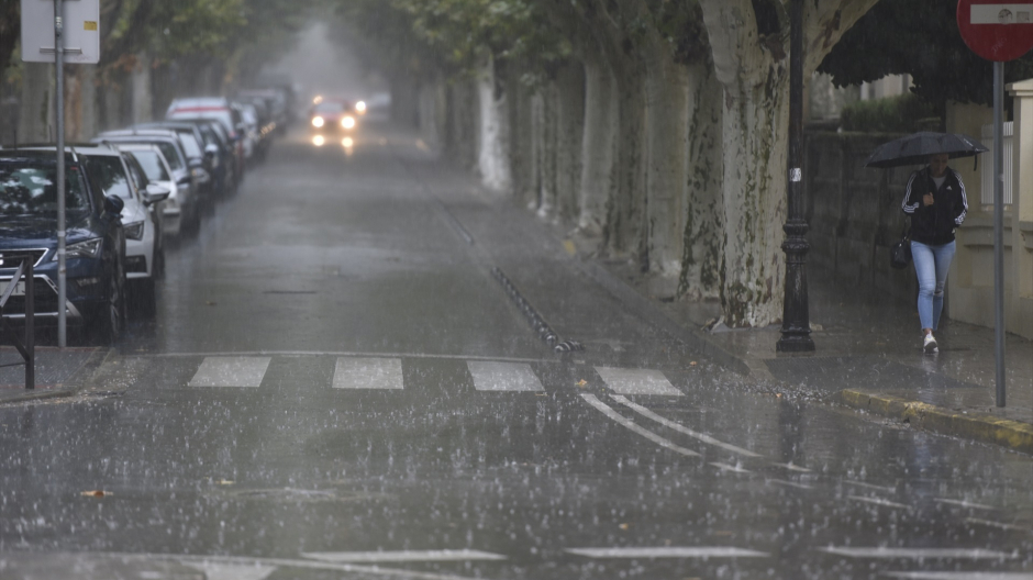 Una persona camina bajo la lluvia provocada por la DANA
