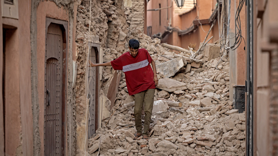 Un hombre trata de caminar por una calle llena de escombros en Marrakech.