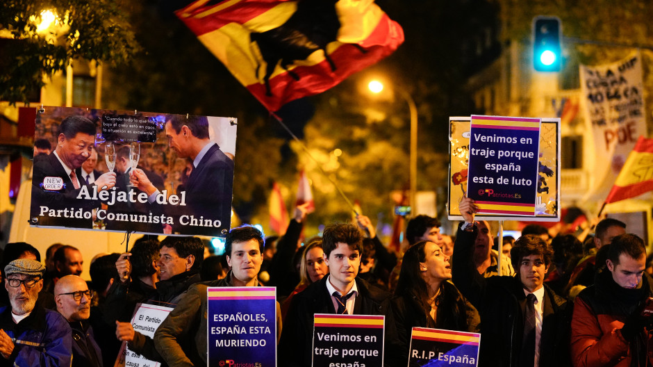 Unos jóvenes vestidos de traje en la manifestación frente a la sede del PSOE