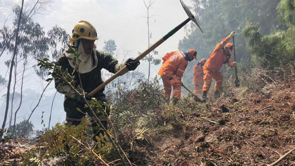 Bomberos trabajando para extinguir el fuego en los cerros orientales de Bogotá