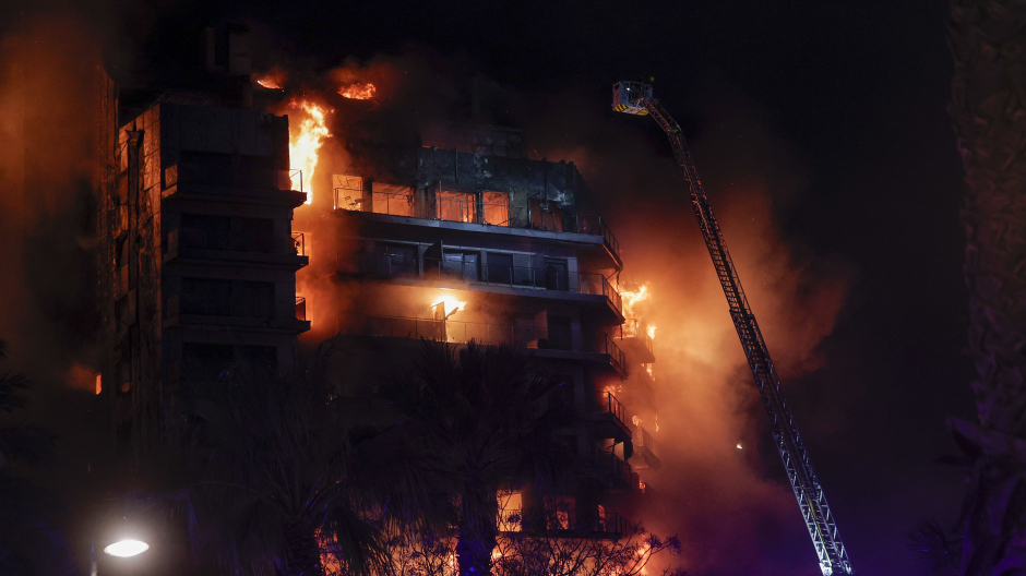 Vista del incendio declarado sobre las cinco y media de esta tarde en un quinto piso de un edificio de viviendas de València que ha afectado totalmente al inmueble y se ha propagado a otro anexo, y los bomberos intentan aún rescatar a vecinos desde los balcones.