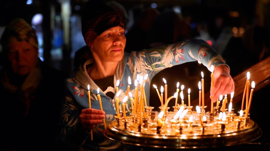 Una ortodoxa enciende una vela de Pascua