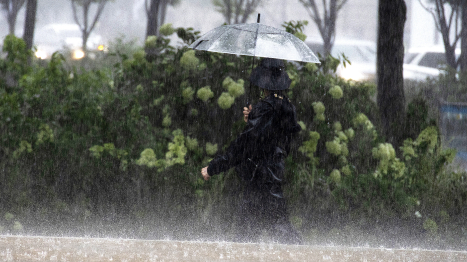 Un hombre camina bajo la fuerte lluvia