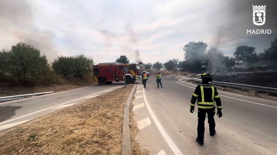 Los bomberos trabajan en la extinción de un incendio de pasto en San Blas, Madrid